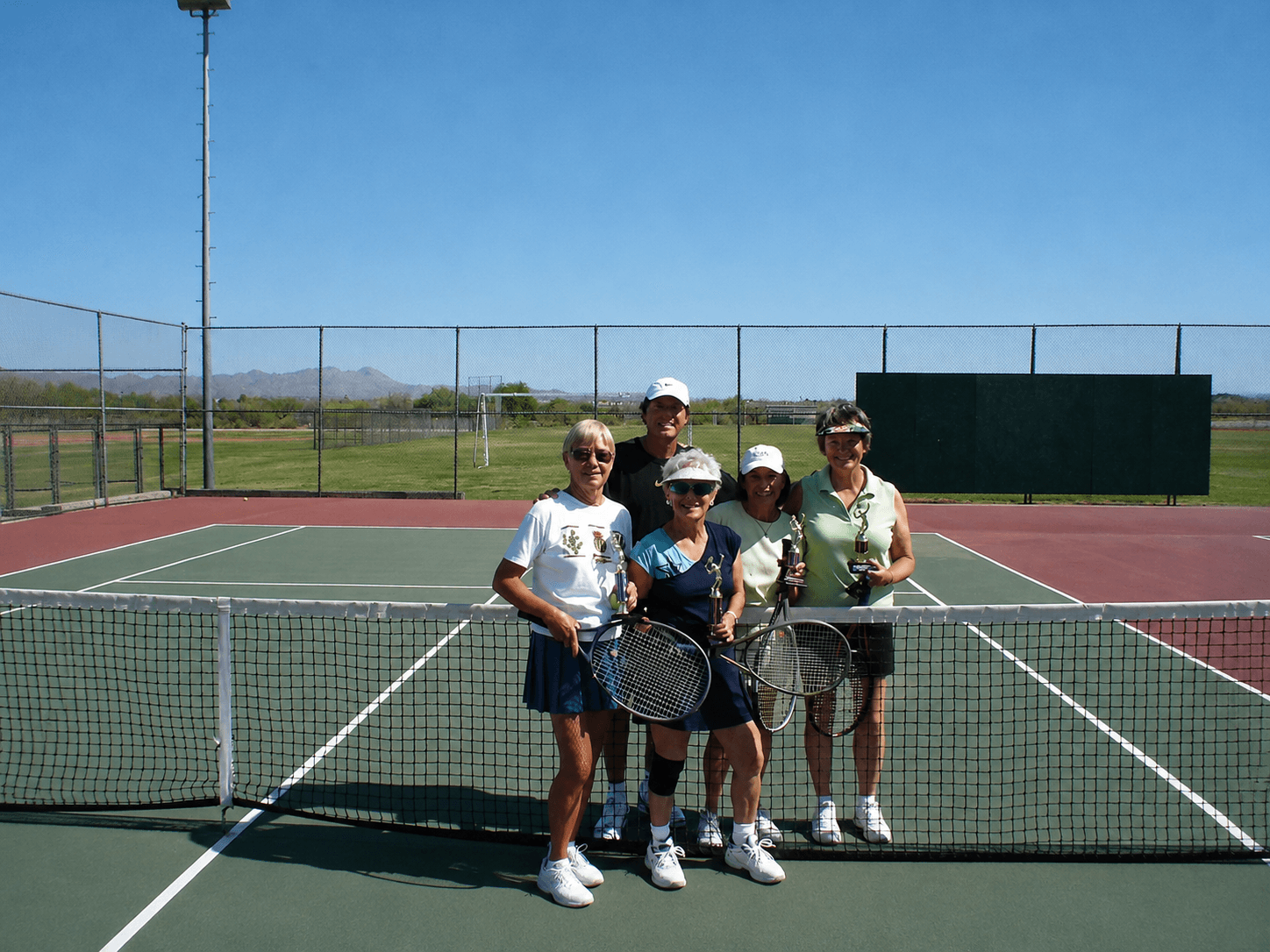 Adult tennis players practicing on court