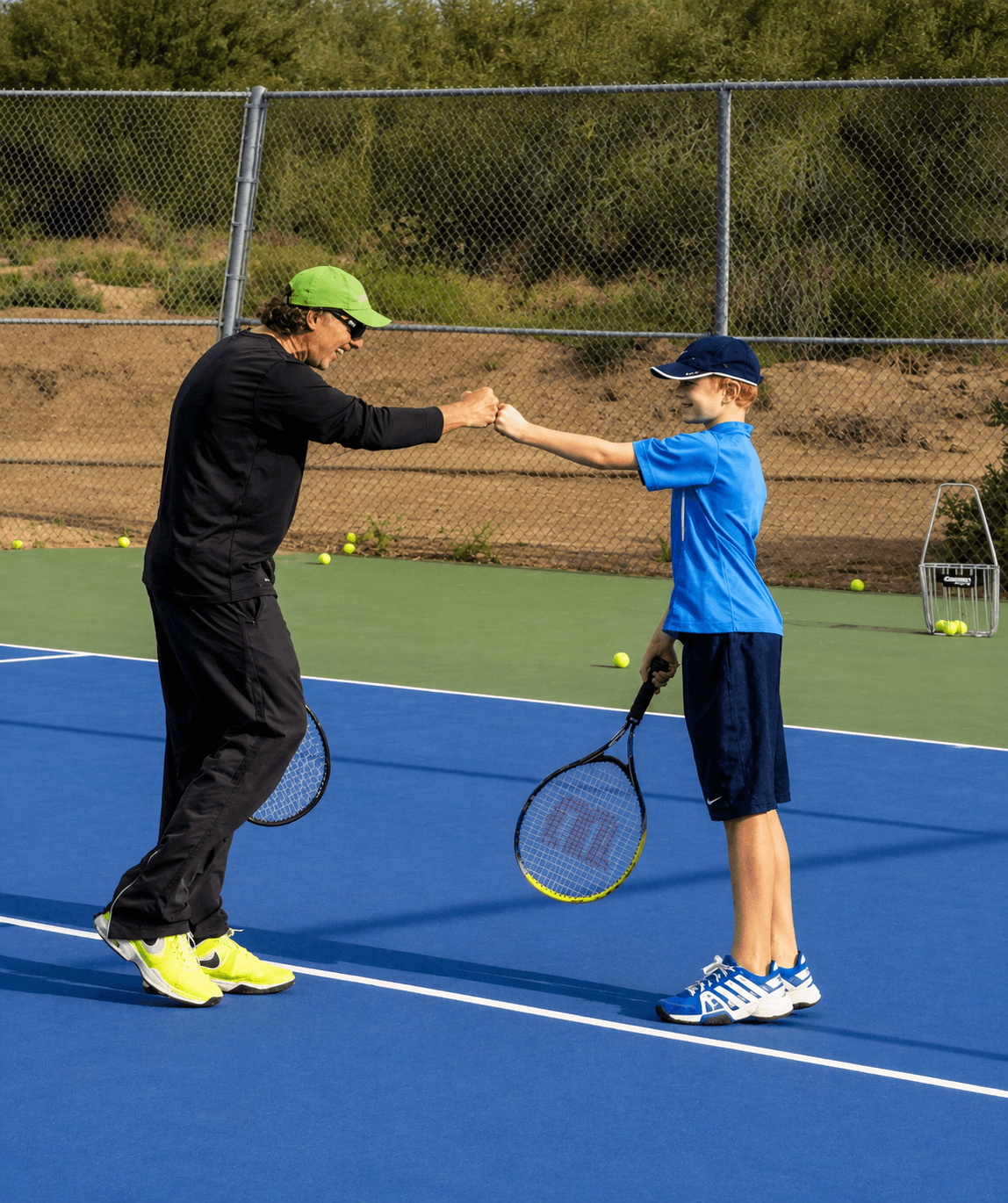 Jorge entrenando a un estudiante joven de tenis