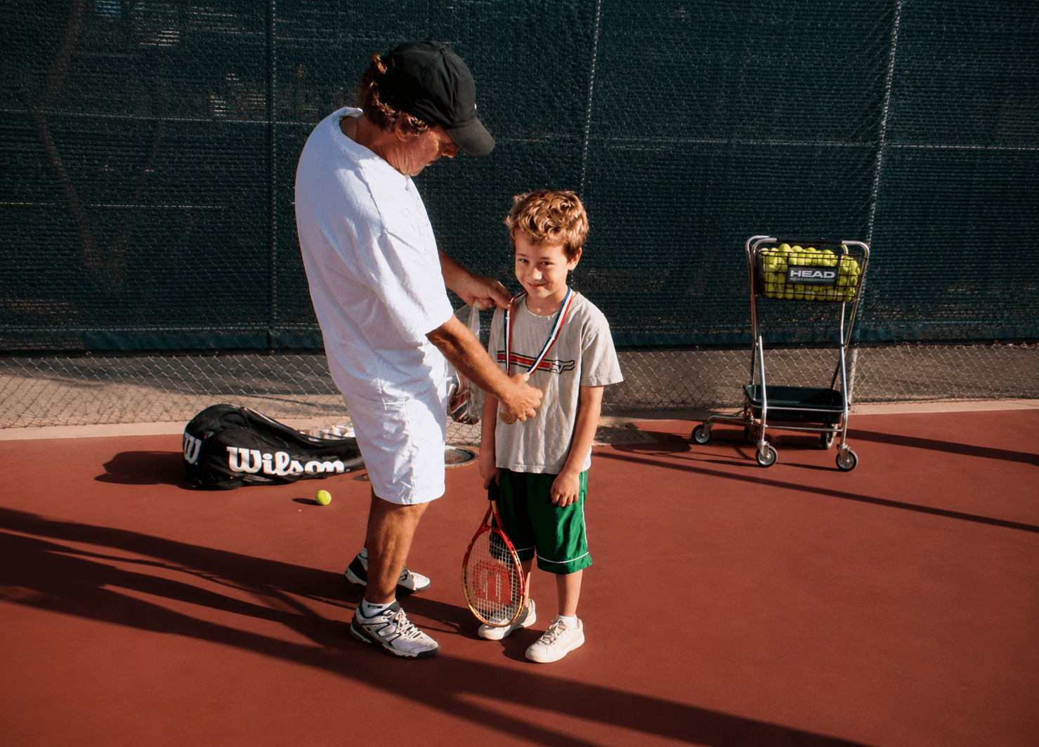 Jorge dando instrucción a un jugador joven de tenis